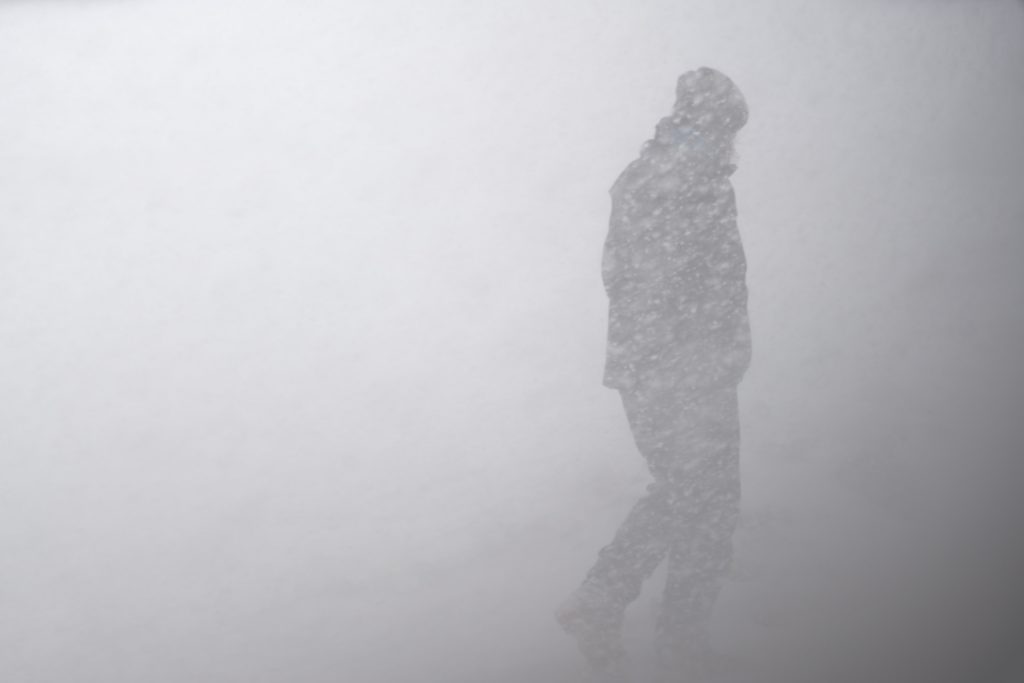 Guy walking in bad snow storm