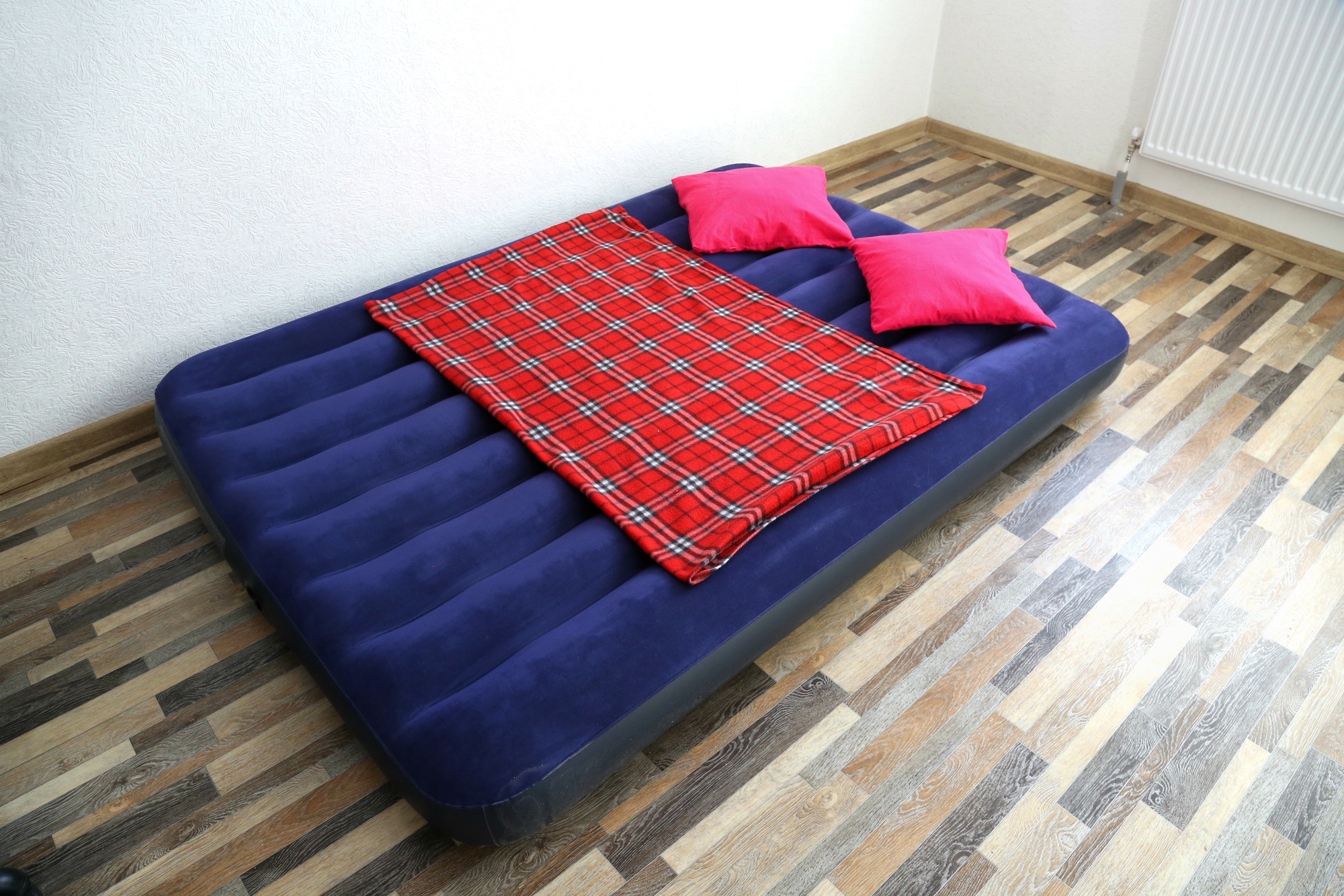 air mattress with a red blanket and pillows